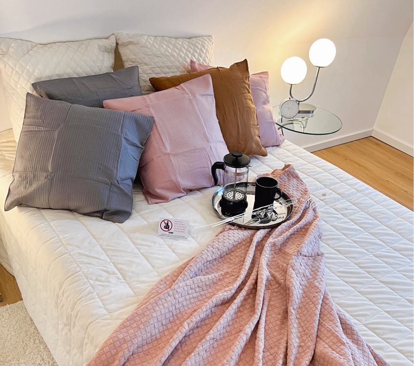 Detailshot von einem Bett mit rosa Akzenten aus einem Home Staging